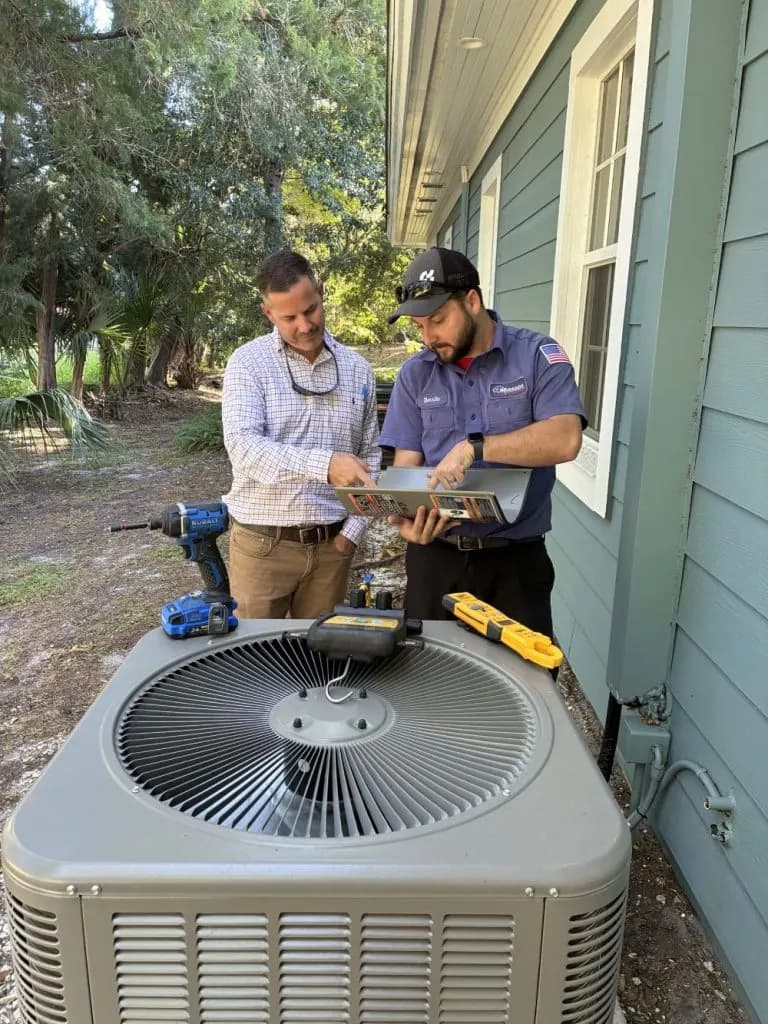Technician points out an AC issue to a homeowner.